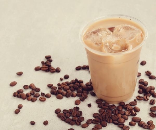 Cup of Ice coffee surrounded by Coffee Island Inc coffee beans